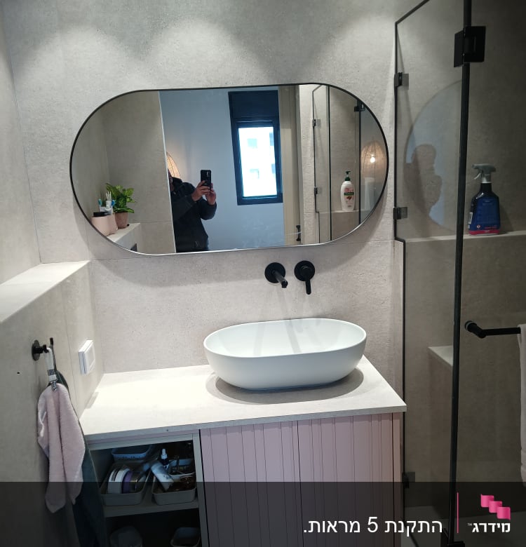 חדר אמבטיה עם כיור, מראה וברזים שחורים